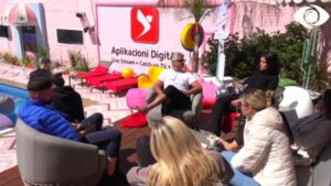 Banorët pinë kafen e mëngjesit dhe bisedojnë në oborr